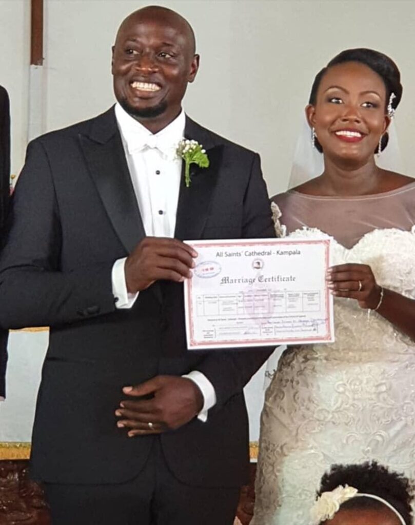 A Ugandan couple holding their marriage certificate. Image Source: nyomplanet