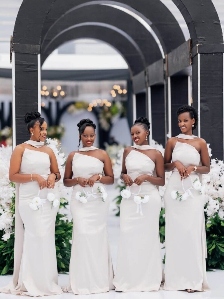 Beautiful Ugandan bridesmaids in their matching dresses at a white wedding. Image Source: Instagram/@peakshotsevents