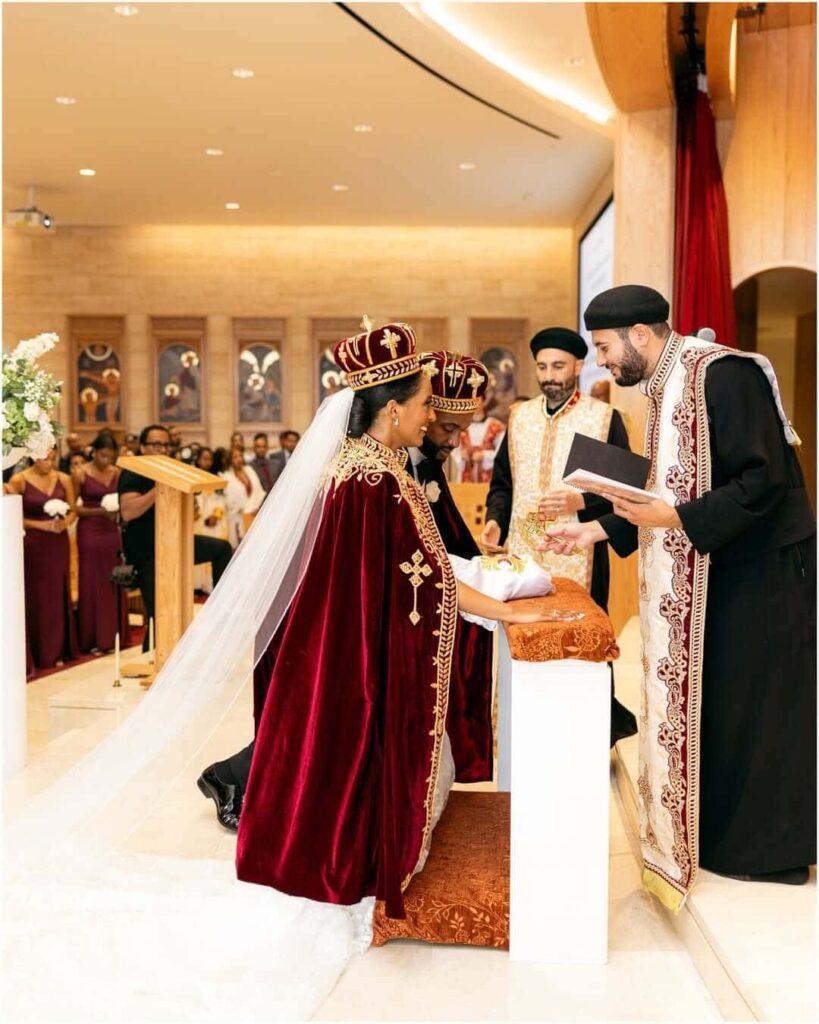 A lovely couple being blessed by a priest at their union in their Orthodox Church wedding, photographed by Getnet Teshome. Image Source: Instagram/@gettphotography